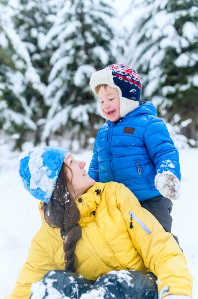 پرتره مادر و کودک در فضای باز در پارک زمستانی پسر مادرش را در آغوش گرفت