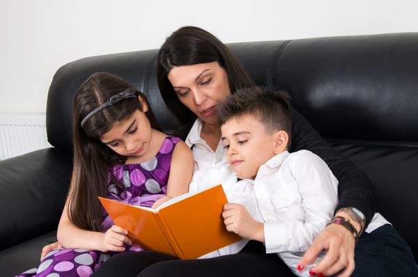 مادر با فرزندان در حال خواندن با هم