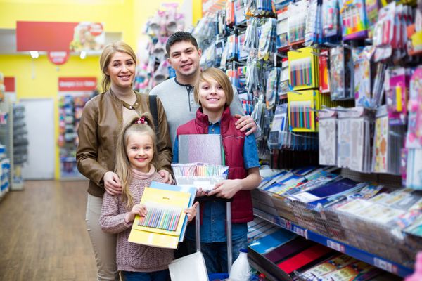خانواده مثبت با کودکان در حال خرید لوازم التحریر در سوپرمارکت تمرکز انتخابی