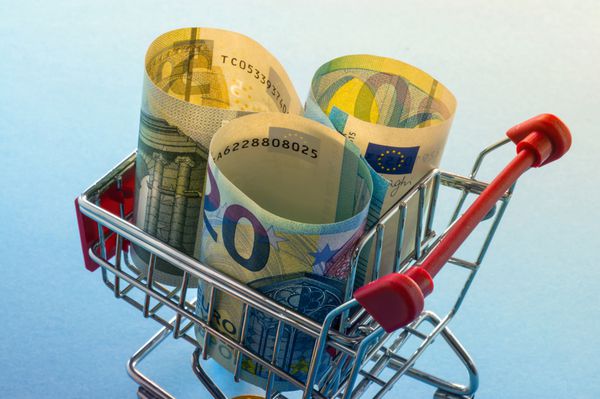 یک سبد خرید با سکه های یورو پو نمادین برای قدرت خرید و مصرف