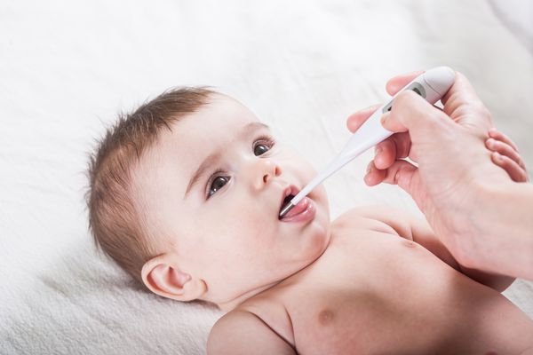 دکتر دمای کودک کوچک را اندازه می گیرد مفهوم مراقبت های بهداشتی و پزشکی در بخش متخصص اطفال