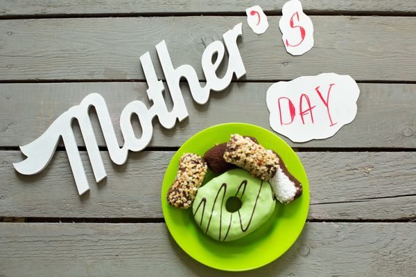 نوشته گل و شیرینی روز مادر روی تخته چوبی