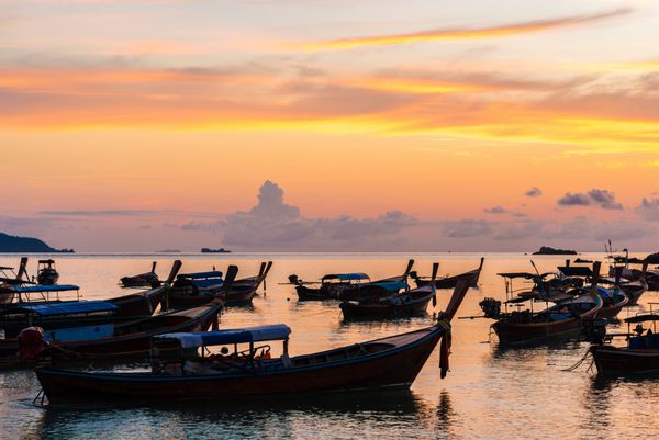 قایق های سنتی تایلندی در ساحل غروب آفتاب شبح قایق ماهیگیر