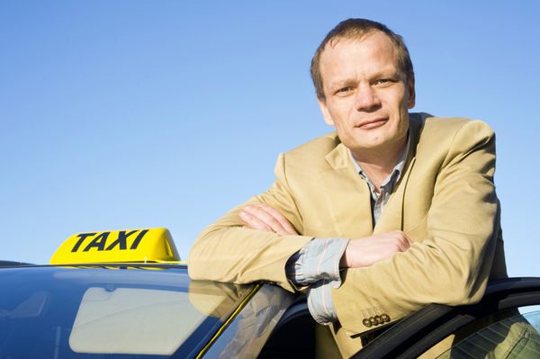 یک راننده تاکسی که پشت در جلوی تاکسی خود عکس گرفته است