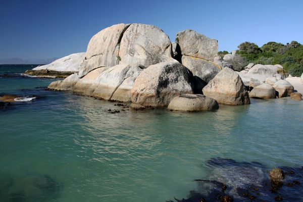تخته سنگ های گرانیتی و آب دریا فیروزه ای در ساحل آفریقای جنوبی