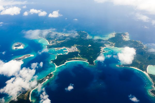 نمای هوایی از جزایر استوایی ژاپن احاطه شده توسط صخره های مرجانی با آب آبی شفاف جزایر کراما اوکیناوا ژاپن