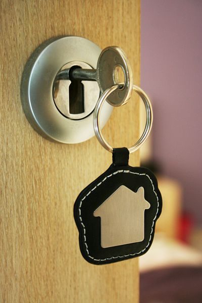 یک کلید در یک قفل با نماد خانه روی آن