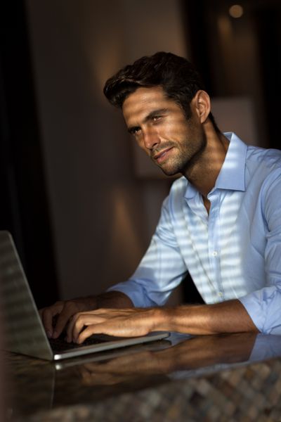 مرد جوان خوش قیافه با کامپیوتر لپ تاپ