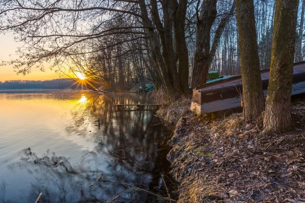 طلوع خورشید بر فراز دریاچه در پایان زمستان