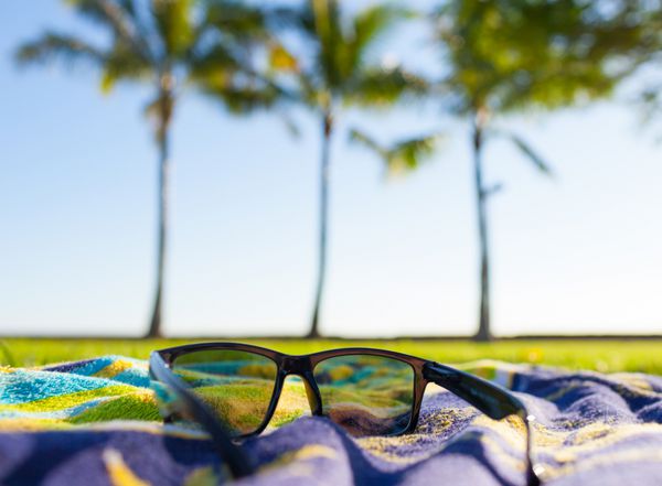 تعطیلات تابستانی نمای نزدیک از عینک آفتابی در یک پارک ساحلی استوایی