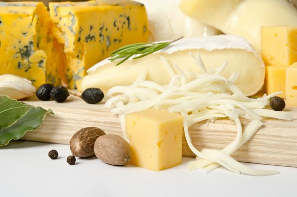 انواع پنیر با ادویه روی تخته چوبی