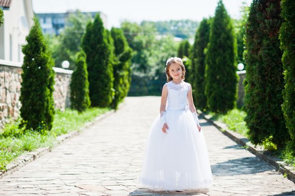 پرتره دختر کوچک ناز روی لباس سفید و تاج گل اول