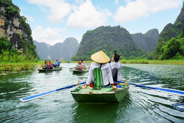 گردشگران در قایق پاروزنانی که از پا برای به حرکت درآوردن پاروها استفاده می کنند ویتنام