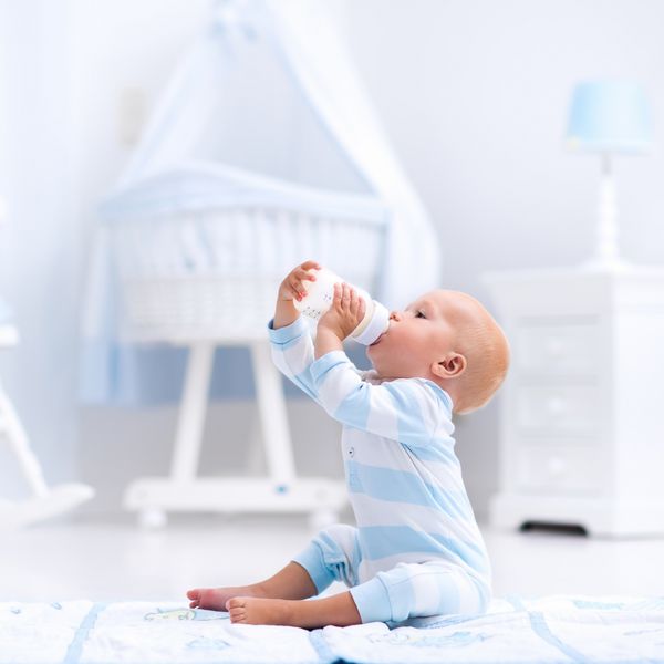 نوزاد پسر در حال نوشیدن شیر در مهد کودک آفتابی