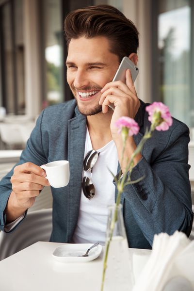 پرتره مرد خوشتیپ در حال نوشیدن قهوه و صحبت کردن در حال صحبت کردن