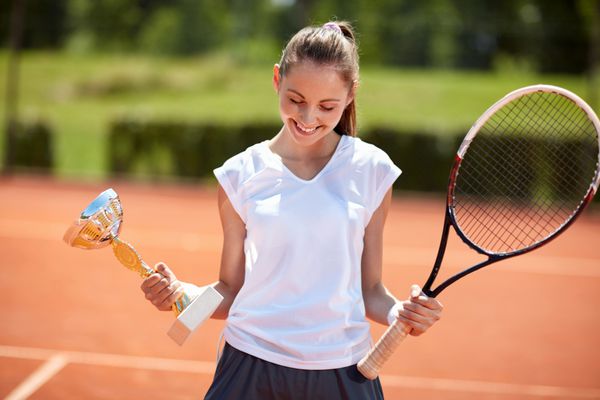 دختری با جام در زمین تنیس