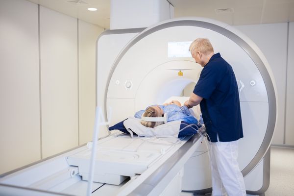 رادیولوژیست زن جوان را برای اسکن MRI آماده می کند