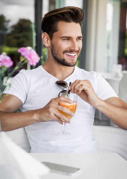 مرد خوشتیپ در حال نوشیدن آب پرتقال