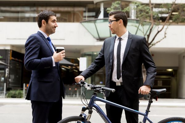 دو تاجر جوان با دوچرخه در مرکز شهر