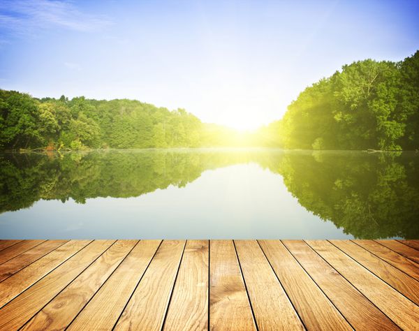 غروب خورشید در دریاچه جنگل و پس زمینه تخته چوبی