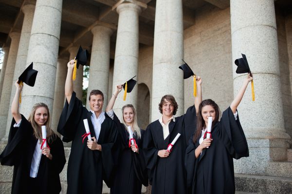 فارغ التحصیلانی که کلاه هایشان را جلوی دانشگاه بالا گرفته اند