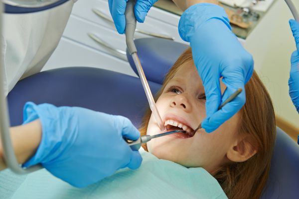 دندانپزشک ارتودنتیست زن پزشک با ابزارهای دندانپزشکی در حین مراقبت از کودک در کلینیک