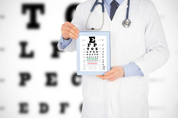 دکتر در حال نشان دادن یک تبلت دیجیتال در برابر آزمایش چشم