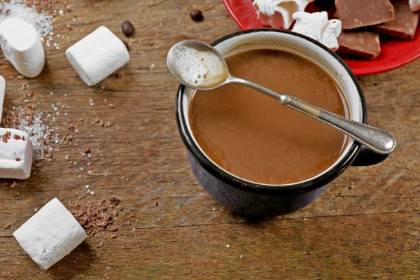 فنجان قهوه با شیرینی در زمینه چوبی
