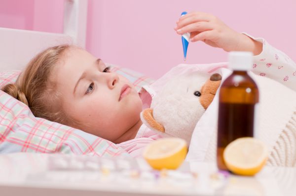 تب سرماخوردگی و آنفولانزا - دارو و چای در جلو دختر بیمار با خرس عروسکی در رختخواب بدون اسم خرس عروسکی