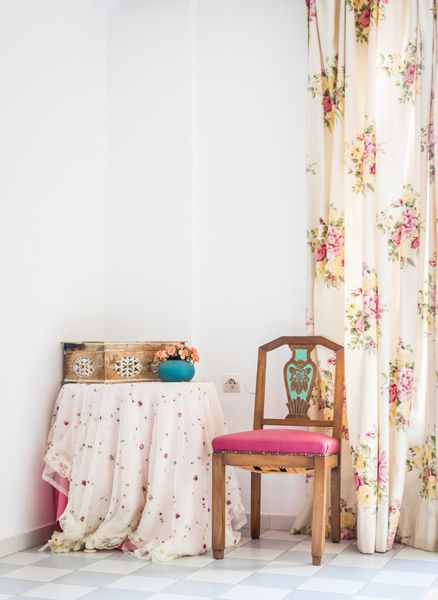 فضای داخلی به سبک وینتیج با میز صندلی حک شده و پرده گلدار