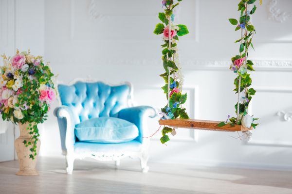 صندلی سبک قدیمی در اتاق داخلی کلاسیک با نور خورشید و گل