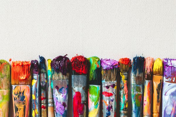 ردیفی از نقاشی‌های هنرمند از نزدیک روی بوم هنری