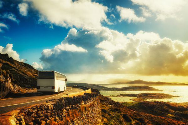 اتوبوس سفید گردشگری در جاده کوهستانی حلقه کری ایرلند مقصد سفر
