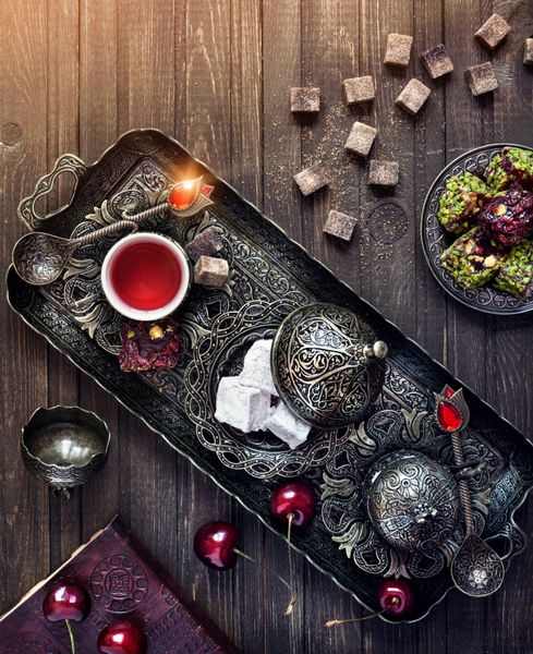 چای با شیرینی ترکی راحت لوکوم و گیلاس روی میز چوبی در رنگ های جادویی با sp برای متن شما