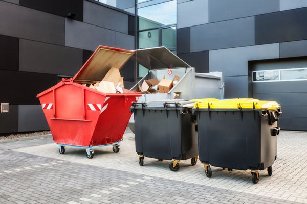 سطل زباله قرمز سطل زباله بازیافت و زباله در نزدیکی ساختمان اداری جدید نمای حیاط خلوت