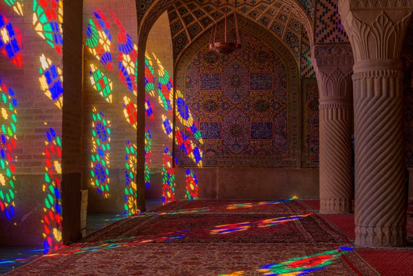 مسجد نصیرالملک یا صورتی در شیراز ایران پنجره های رنگ آمیزی جلوه ای رنگی روی فرش ها ستون ها و دیوارها در صبح ایجاد می کنند