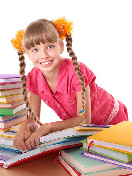 کودک در حال خواندن کتاب باز روی میز