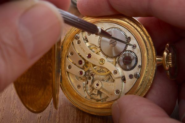 عقربه هایی که ساعت جیبی قدیمی را تعمیر می کنند