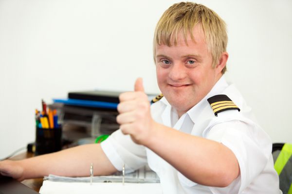 خلبان معلول جوان در حال نشان دادن شست بالا در دفتر