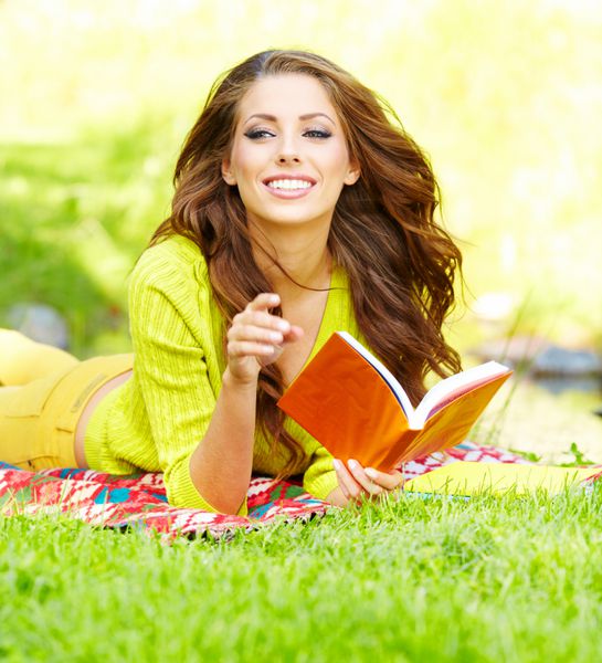 دختر زیبا با کتاب در پارک