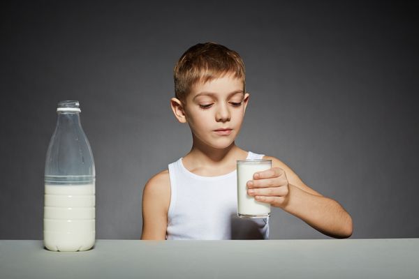 پسری که به لیوان شیر نگاه می کند