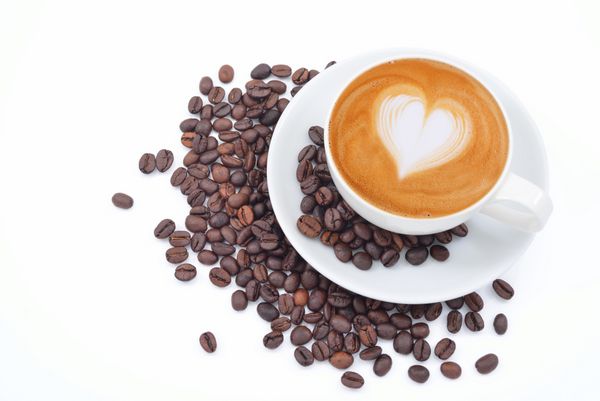 یک فنجان کافه لاته و دانه های قهوه روی سفید