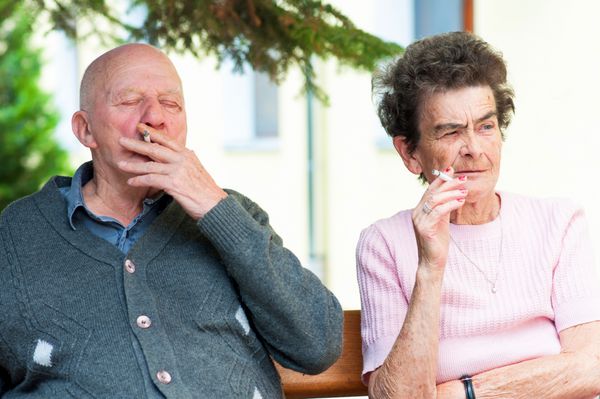 زن و شوهر پیر در حال کشیدن سیگار