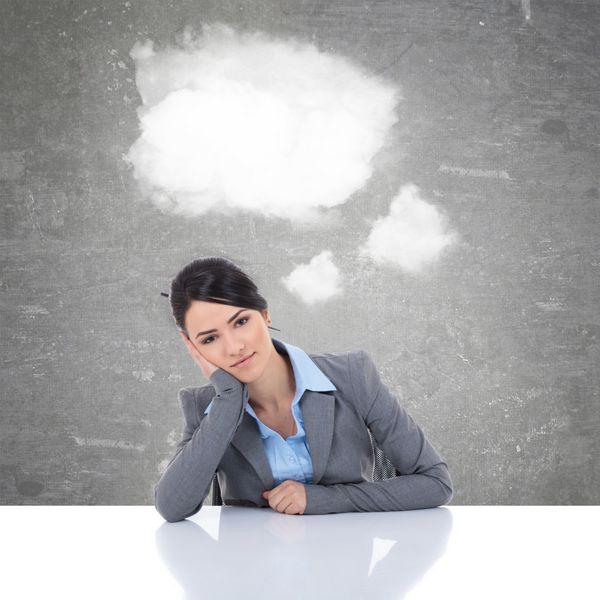 زن تجاری پشت میزش با ابرها به عنوان حباب گفتار