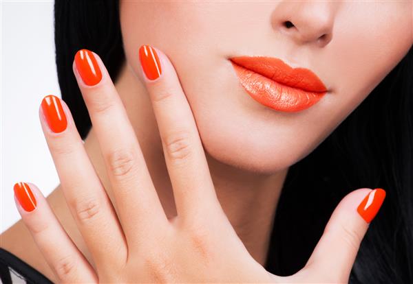 دست زن نزدیک با ناخن های نارنجی زیبا در فولکس زنانه