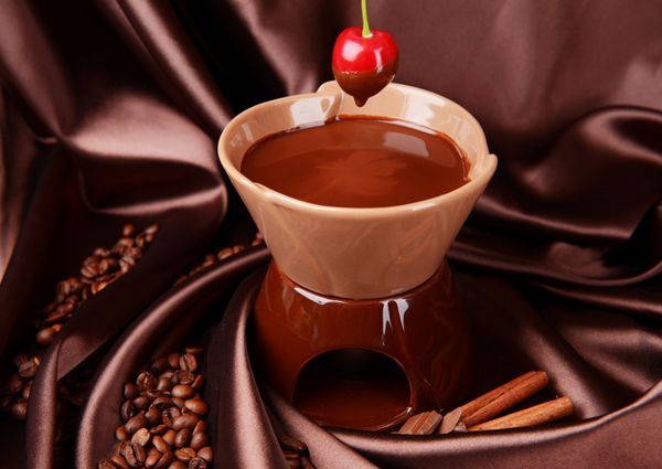 فوندو شکلاتی با میوه ها در زمینه قهوه ای