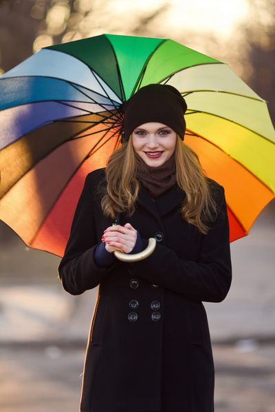 دختر زیبای قفقازی که با چتر ژست گرفته است