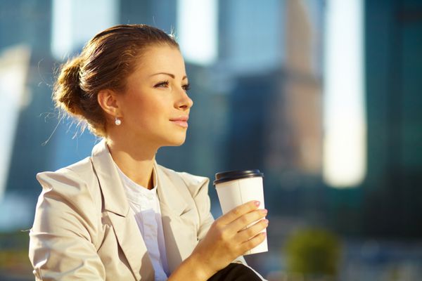 پرتره زن جوان ناز با فنجان قهوه در فضای باز