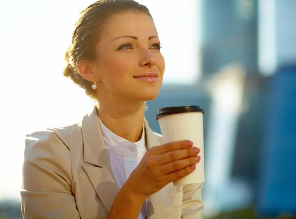 پرتره زن جوان ناز با فنجان قهوه در فضای باز