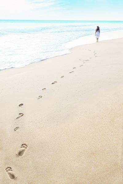 رد پا با قدم زدن زن در ساحل استوایی در مالدیو
